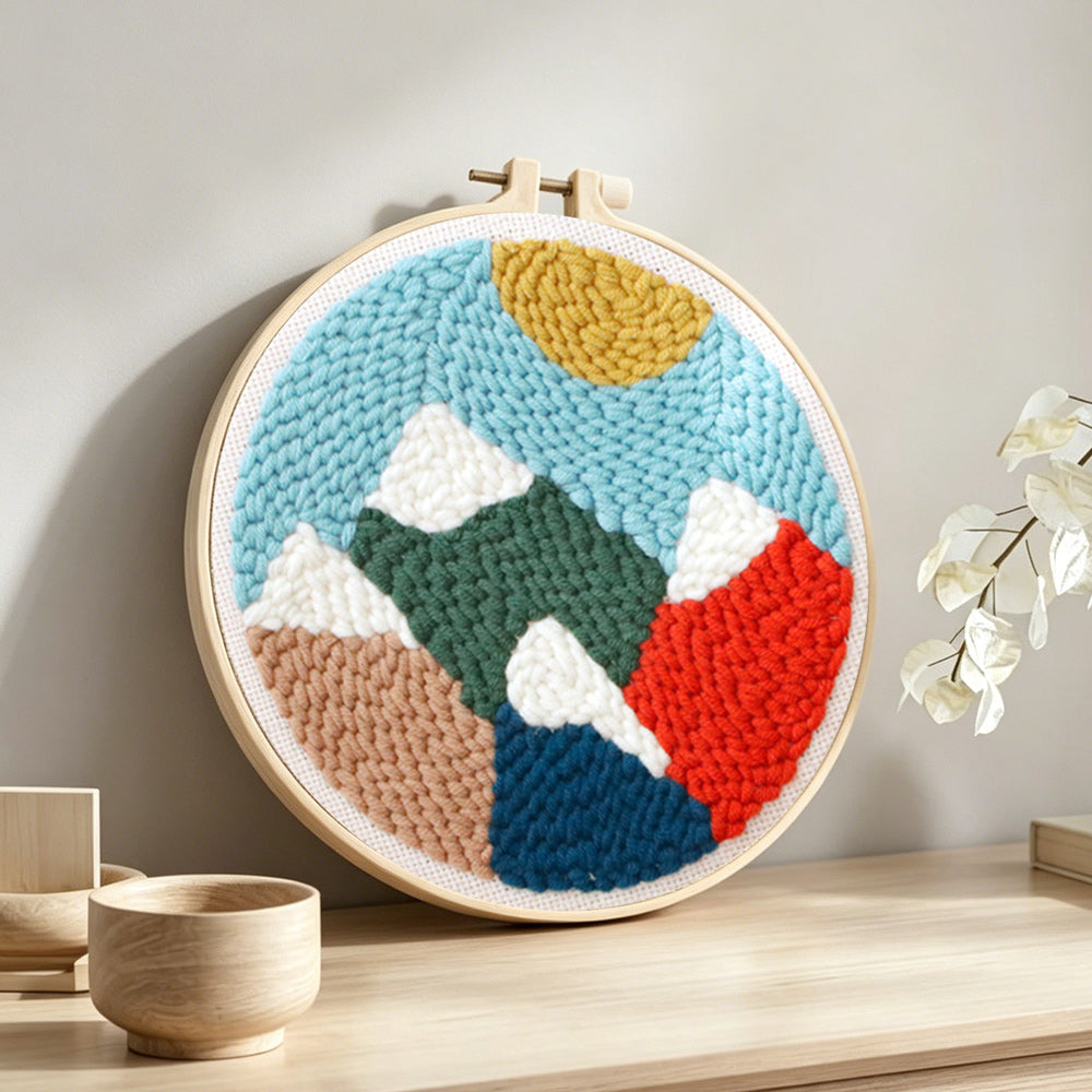 Colourful mountain landscape punch needle artwork displayed on a table