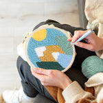 Creating handmade colourful mountain landscape with sun punch needle artwork