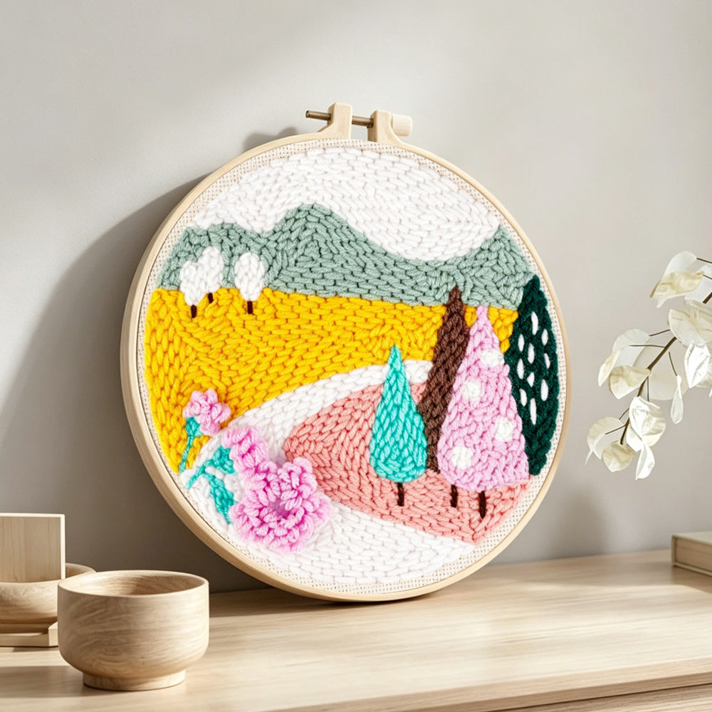 Colourful mountains and trees punch needle artwork displayed on a table
