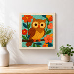 Finished colourful owl on flowering branch artwork displayed on a wall