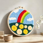 Colourful rainbow with yellow roses punch needle artwork displayed on a table