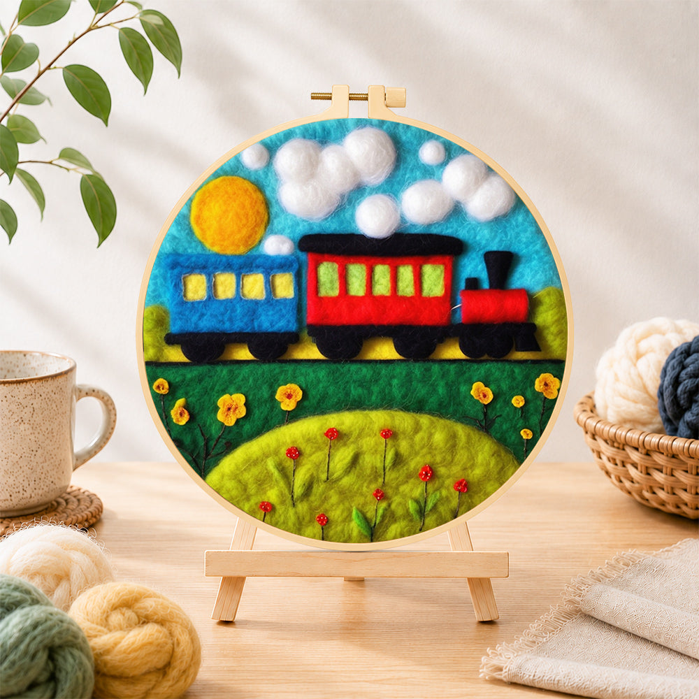 Finished colourful train on grass needle felting displayed on a wooden easel