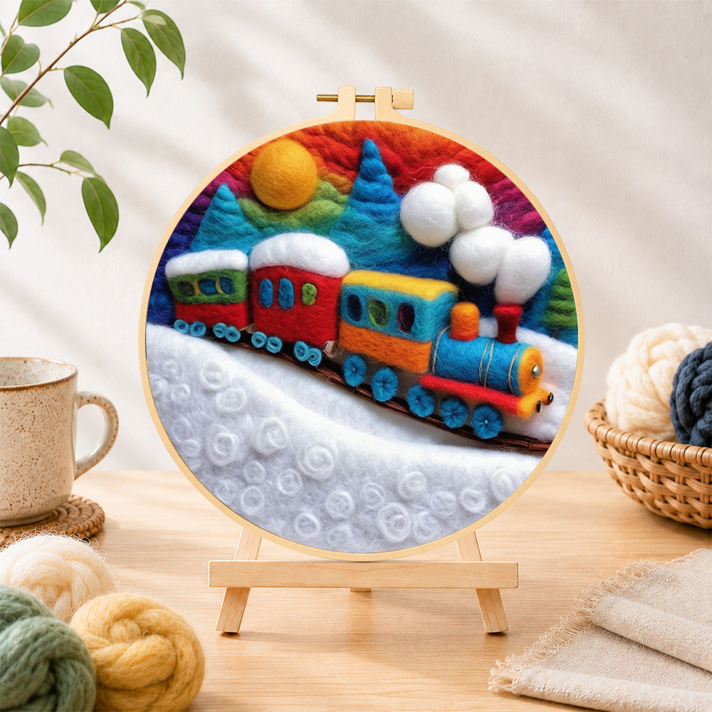 Finished colourful train on snowy hills needle felting displayed on a wooden easel