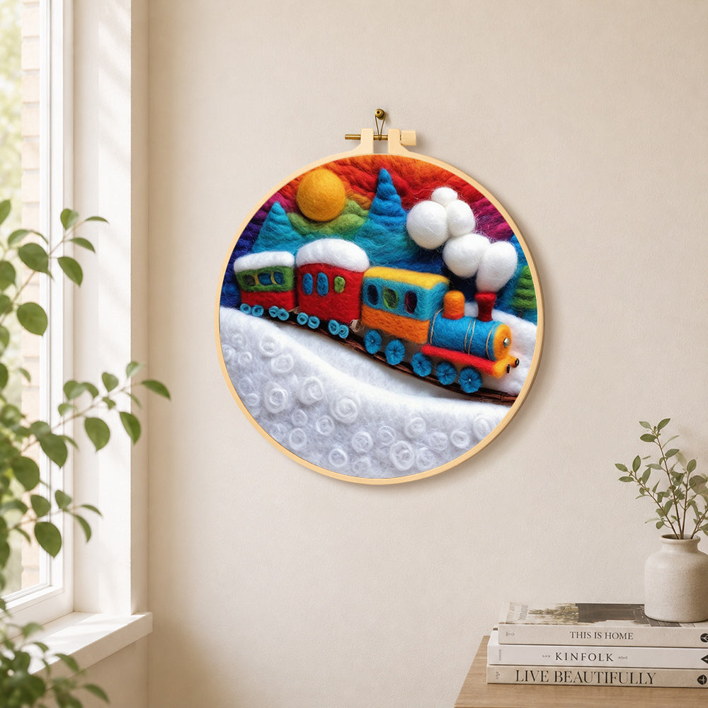 Colourful train on snowy hills needle felt wall art displayed in a bright home interior