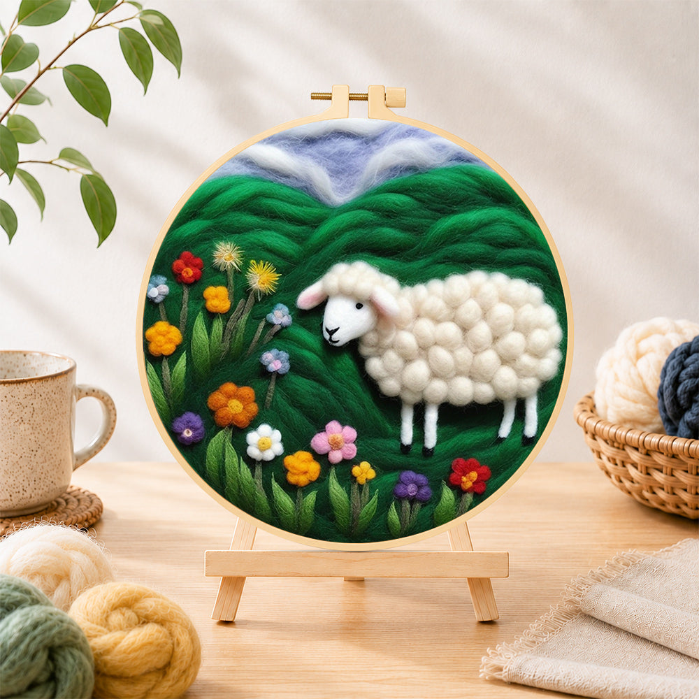 Finished colourful wildflower meadow with a sheep needle felting displayed on a wooden easel