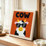 Cool sunglasses cow punch needle artwork displayed on a table