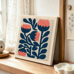 Coral and navy flowers punch needle artwork displayed on a table
