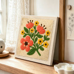 Coral and yellow florals punch needle artwork displayed on a table