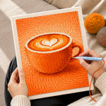 Creating handmade cosy orange coffee cup with heart latte art punch needle artwork