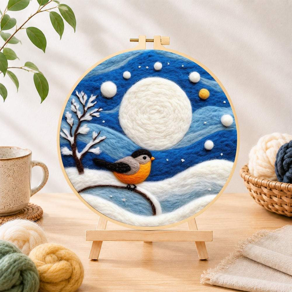 Finished cosy winter bird under the full moon needle felting displayed on a wooden easel