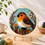 Finished cosy woodland bird needle felting displayed on a wooden easel