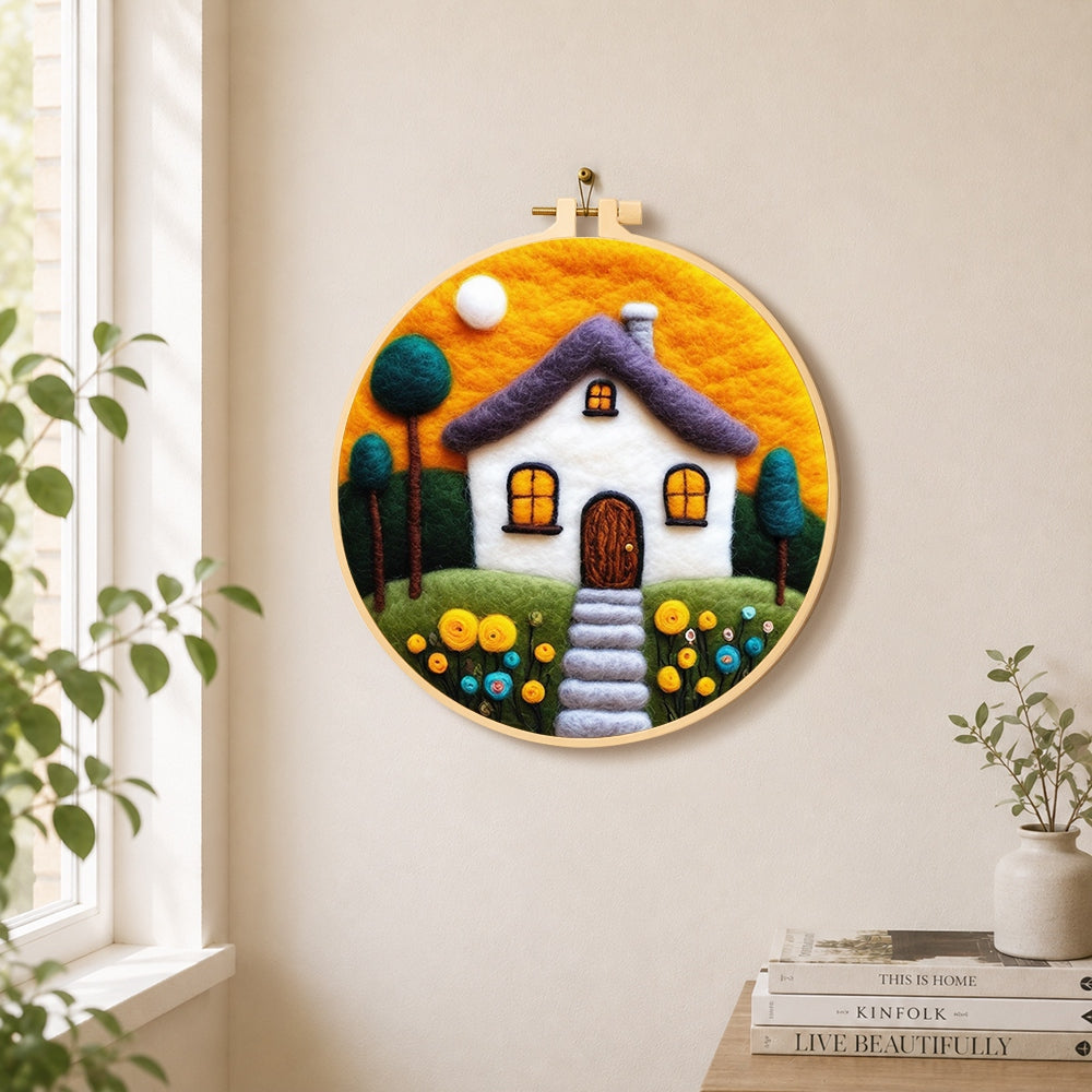 Cozy cottage and orange sunset needle felt wall art displayed in a bright home interior