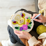 Creating handmade cream floral highland cow punch needle artwork