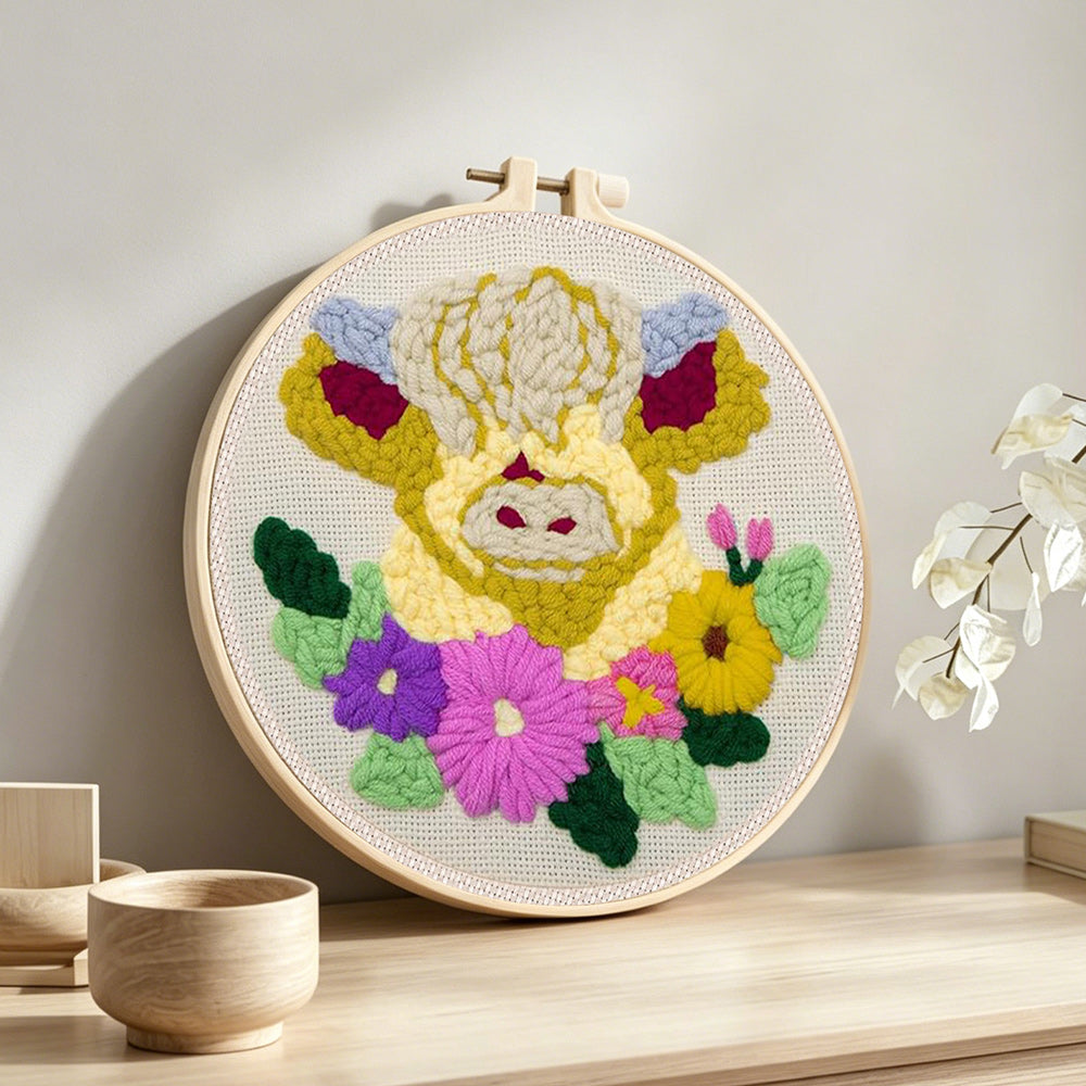 Cream floral highland cow punch needle artwork displayed on a table