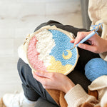 Creating handmade crescent moon over colourful clouds punch needle artwork