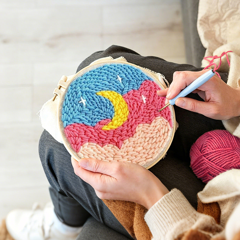 Creating handmade crescent moon over pink and blue cloud sky punch needle artwork
