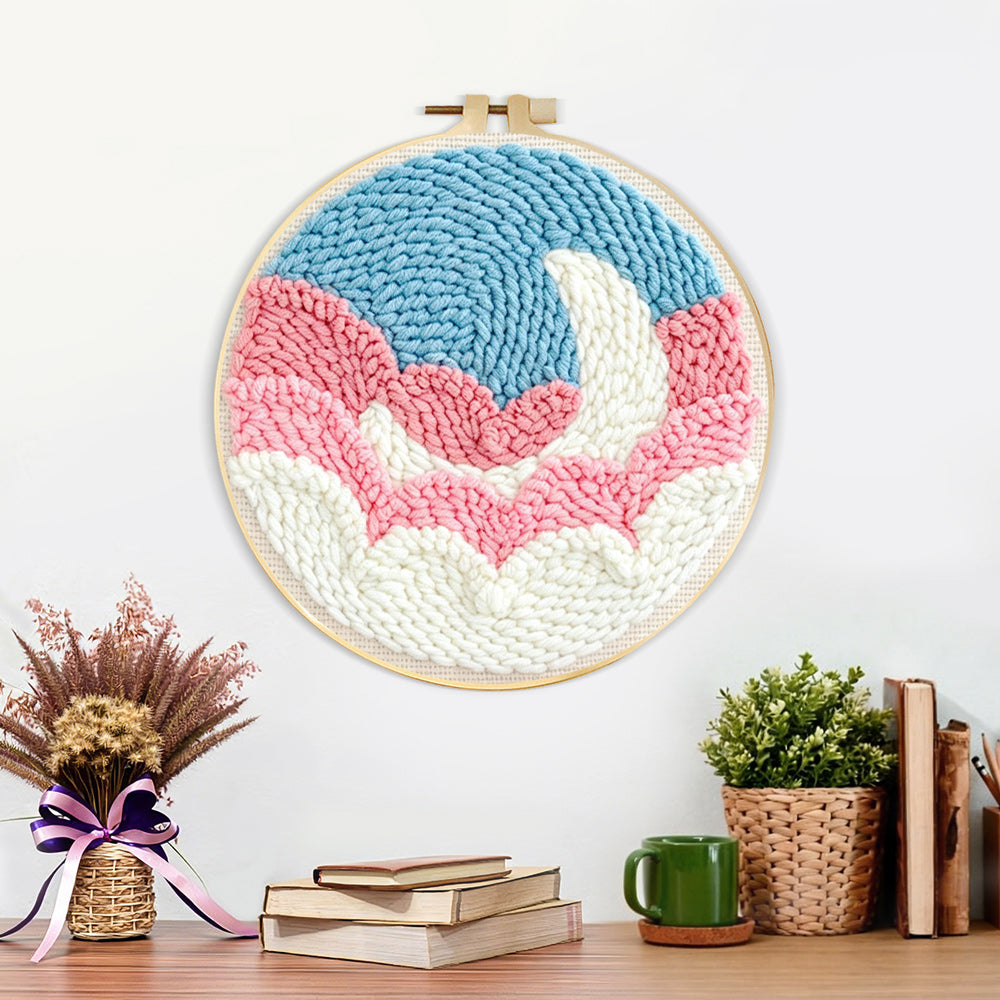 Finished crescent moon over pink and white clouds artwork displayed on a wall