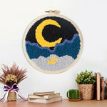 Finished crescent moon, sea and mountains artwork displayed on a wall