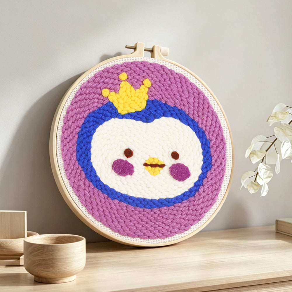 Crowned princess penguin punch needle artwork displayed on a table