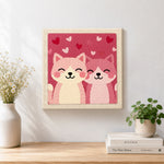 Finished cuddly pink cat duo artwork displayed on a wall