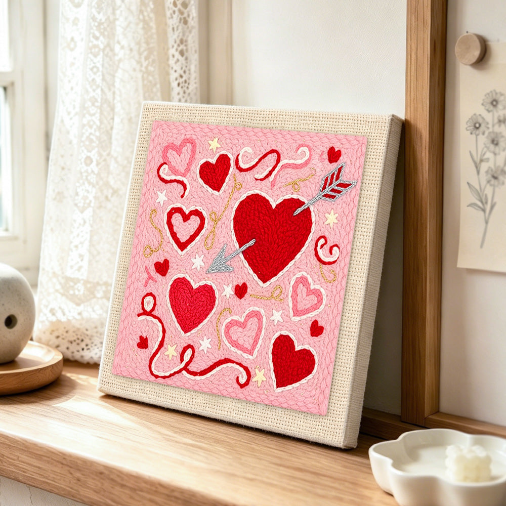 Cupid's arrow target heart punch needle artwork displayed on a table