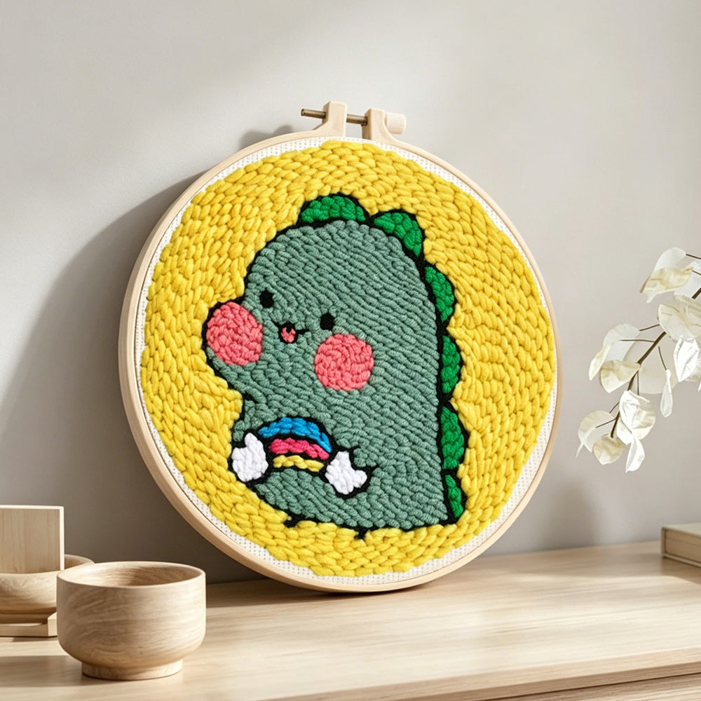 Cute baby dinosaur punch needle artwork displayed on a table