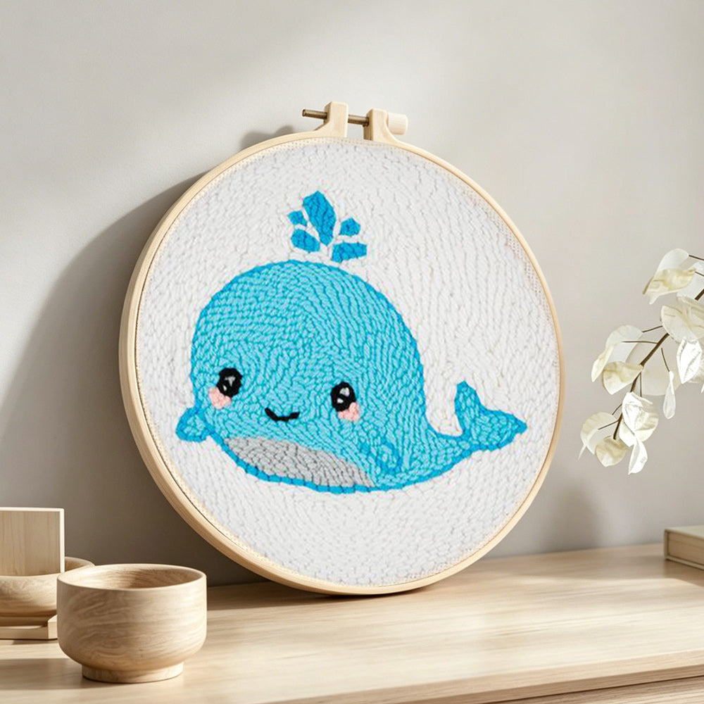 Cute baby whale punch needle artwork displayed on a table
