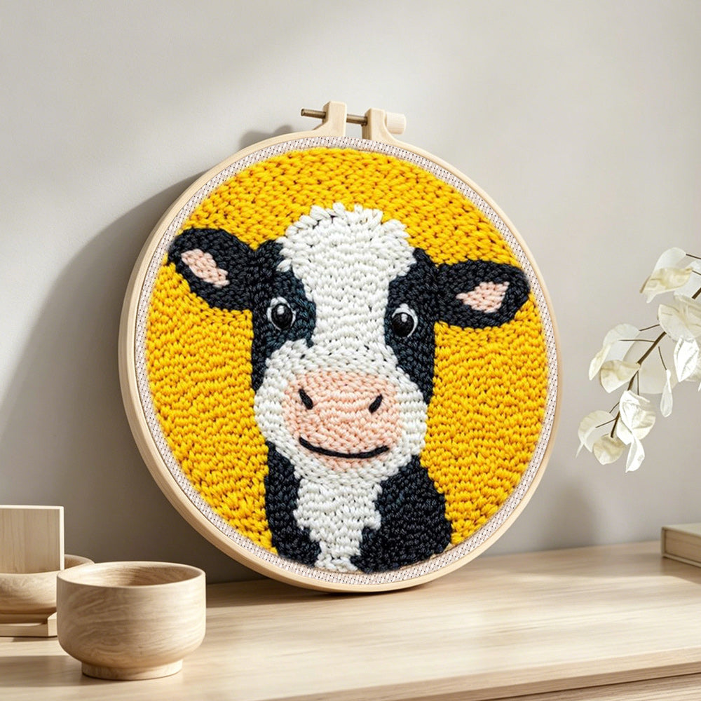Cute black and white cow punch needle artwork displayed on a table