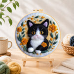 Finished cute black and white kitten needle felting displayed on a wooden easel