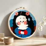 Cute black haired girl punch needle artwork displayed on a table