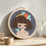 Cute brown haired girl punch needle artwork displayed on a table