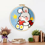 Finished cute bunny holding hear artwork displayed on a wall