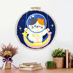 Finished cute calico cat astronaut on rainbow moon artwork displayed on a wall