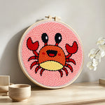 Cute cartoon crab punch needle artwork displayed on a table