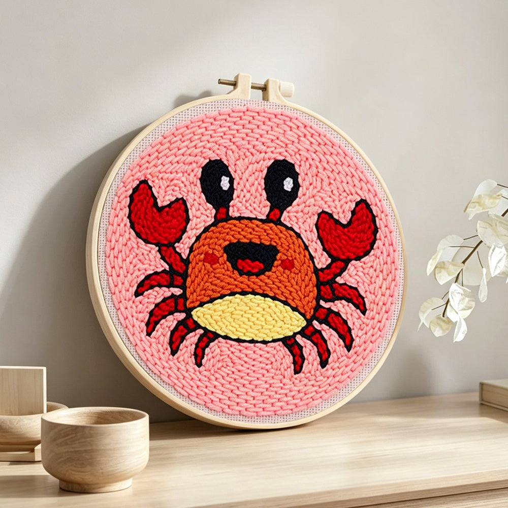 Cute cartoon crab punch needle artwork displayed on a table