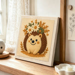 Cute floral crown hedgehog punch needle artwork displayed on a table
