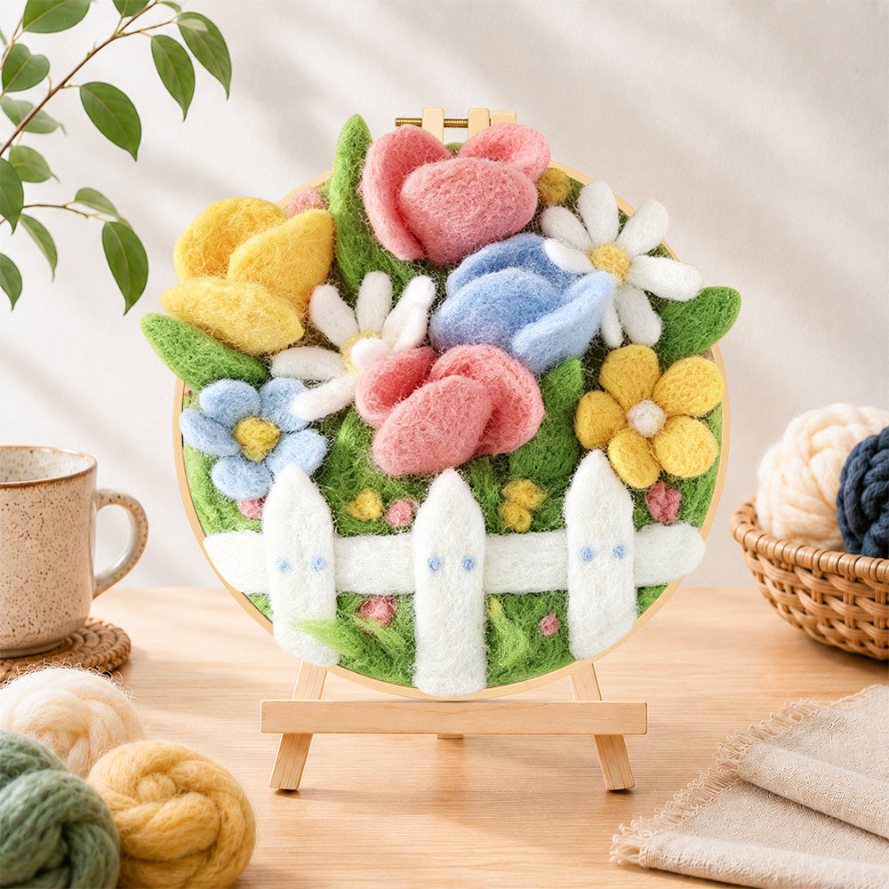 Finished cute flower bed with white picket fence needle felting displayed on a wooden easel