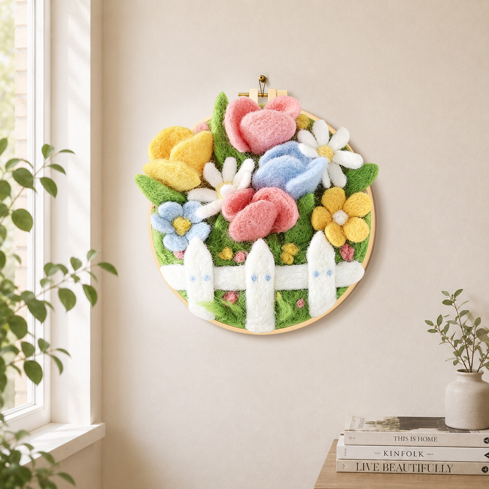 Cute flower bed with white picket fence needle felt wall art displayed in a bright home interior