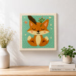 Finished cute fox with feathers and sprigs artwork displayed on a wall