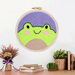 Finished cute frog face artwork displayed on a wall