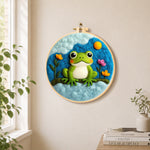 Cute green frog under the cloud needle felt wall art displayed in a bright home interior