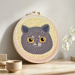 Cute grey cat punch needle artwork displayed on a table