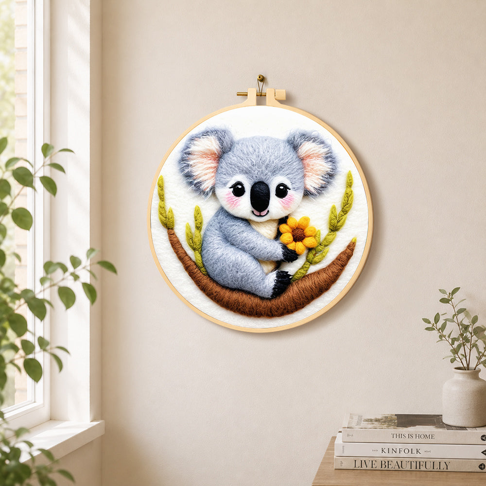 Cute koala holding a flower needle felt wall art displayed in a bright home interior