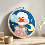 Cute nap duck punch needle artwork displayed on a table