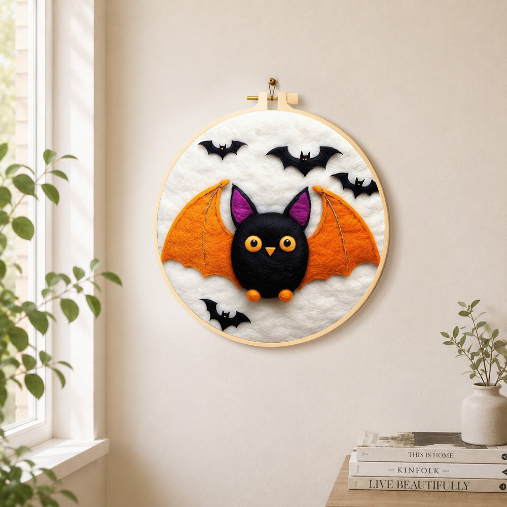 Cute orange-winged bat needle felt wall art displayed in a bright home interior