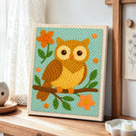 Cute owl on branch punch needle artwork displayed on a table