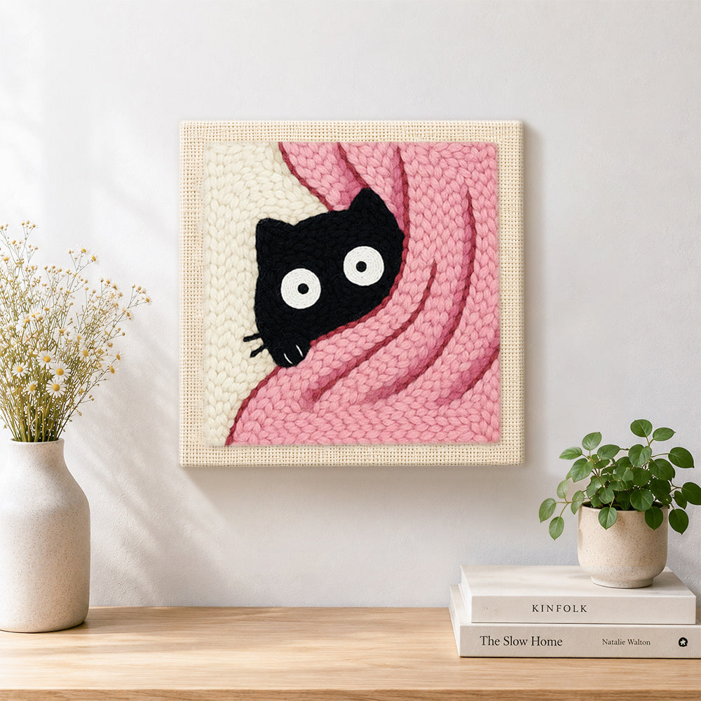 Finished cute peeking kitten in pink blanket artwork displayed on a wall