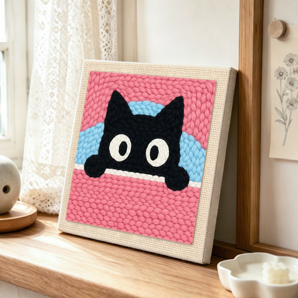 Cute peeking kitten punch needle artwork displayed on a table