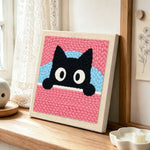 Cute peeking kitten punch needle artwork displayed on a table