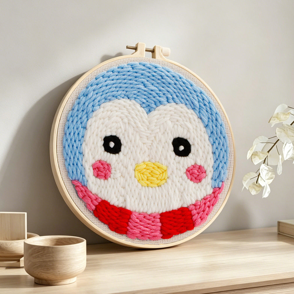 Cute penguin face punch needle artwork displayed on a table